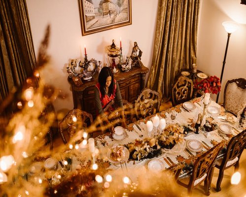 A warm lit dining room table prepared for an extended peaceful family dinner gathering
