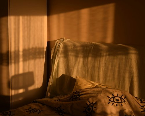 A cozy bedroom corner with dim warm lamp lighting conducive to deep sleep and undisturbed rest